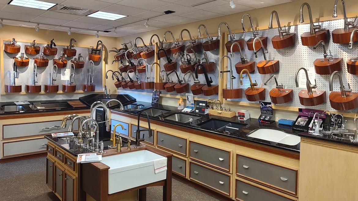 The 'Before' of the Lion Plumbing Supply showroom, here showing a display of faucets on the wall and sinks.