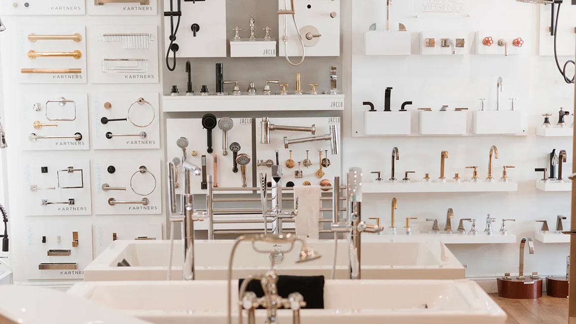 Lion Plumbing Supply showroom remodel showing a row of bathtubs and a wall of bathroom fixture samples.