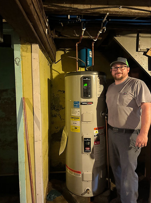 Installer posing next to Aerotherm installation.