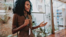 Woman speaker holding a microphone while giving a presentation.