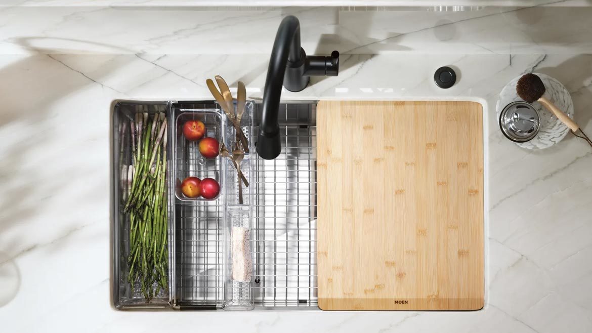 Overhead view of a sink with a vegetable rack and chopping board.