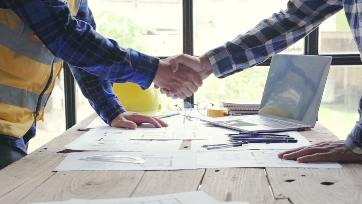 Engineer talking with his client and shaking hands. 