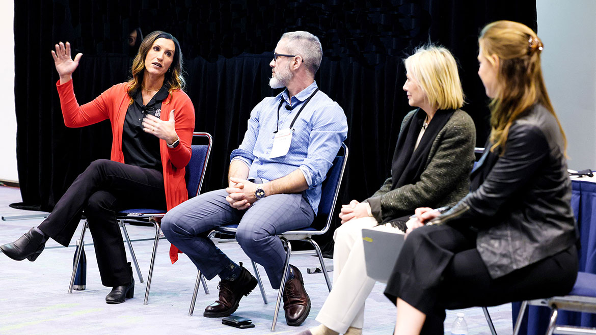 Four people having a discussion during a seminar.