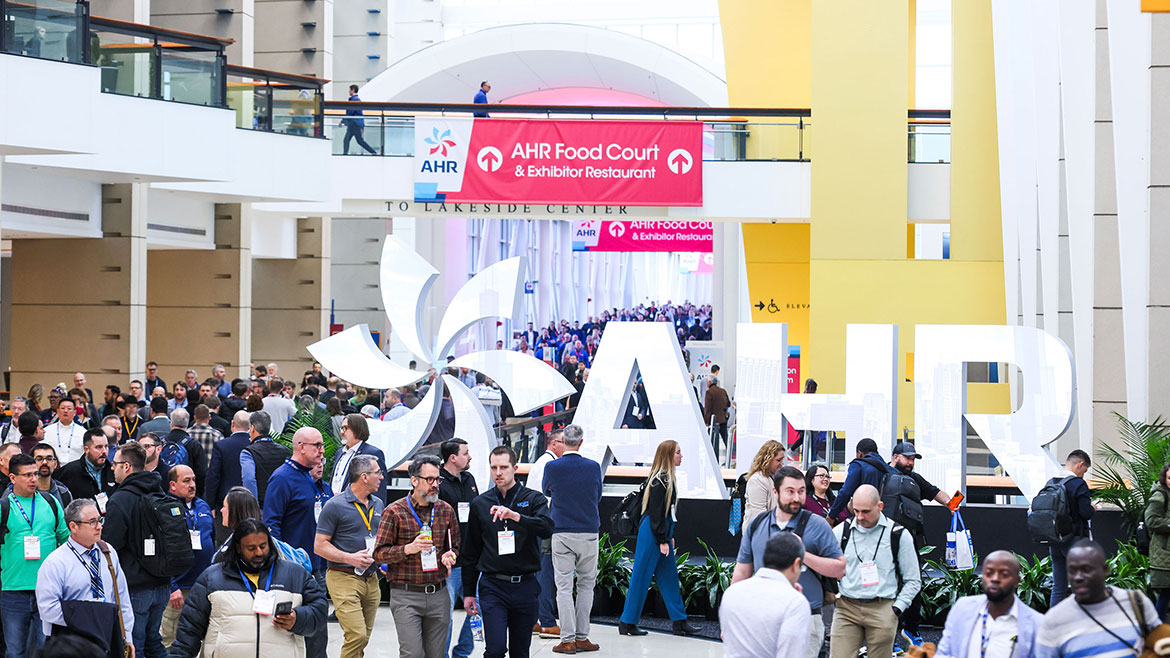 Attendees by a large AHR sign